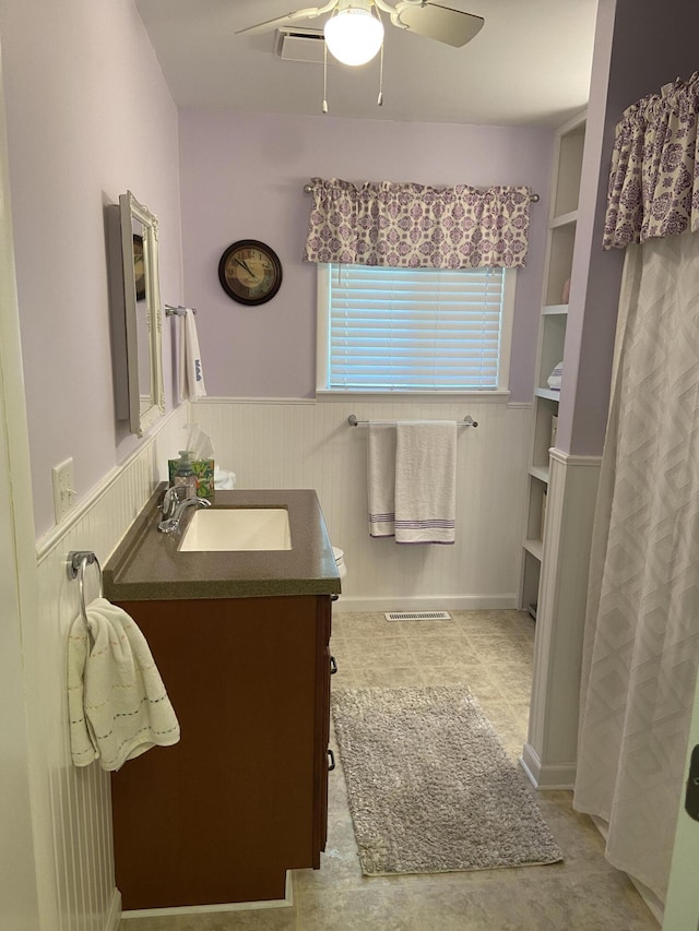 3350 Woodcrest Dr, Lewiston, MI 49756 - bathroom with a ceiling fan, vanity, and wainscoting