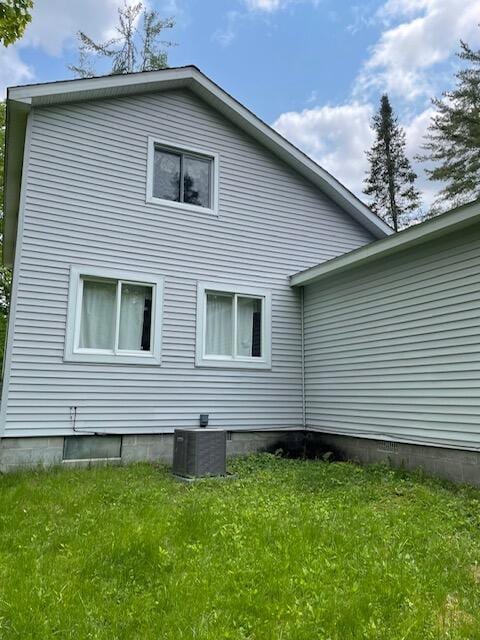 22551 Theiner Trl, Hillman, MI 49746 - view of side of home featuring a lawn and a central air condition unit