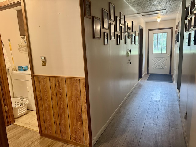 36 S Mcmasters Bridge Rd, Grayling, MI 49738 - hallway with washer / dryer, a wainscoted wall, a textured ceiling, wood finished floors, and wooden walls