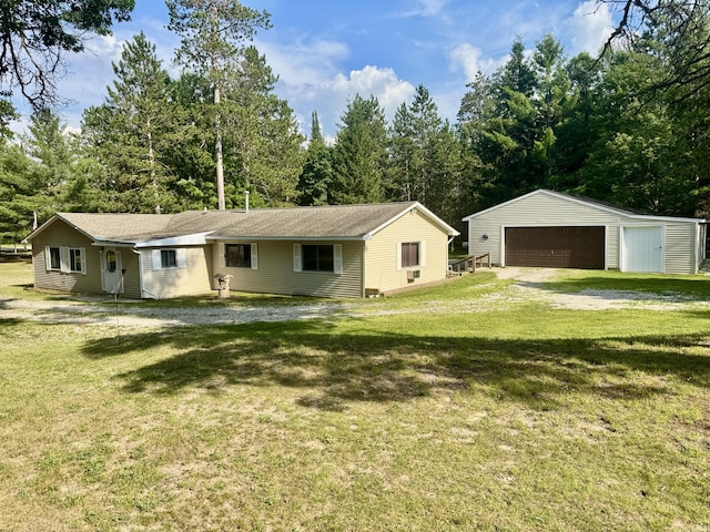 36 S Mcmasters Bridge Rd, Grayling, MI 49738 - view of front of property featuring a detached garage, an outbuilding, a front yard, and view of scattered trees