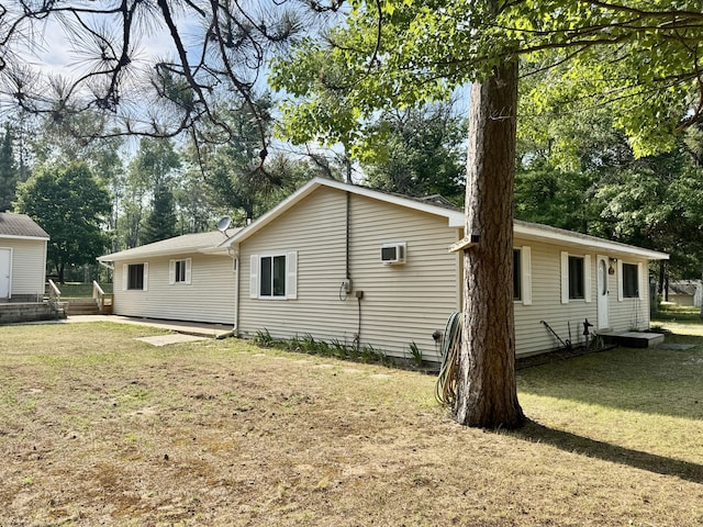 36 S Mcmasters Bridge Rd, Grayling, MI 49738 - view of side of property with a yard, a wall unit AC, and view of scattered trees