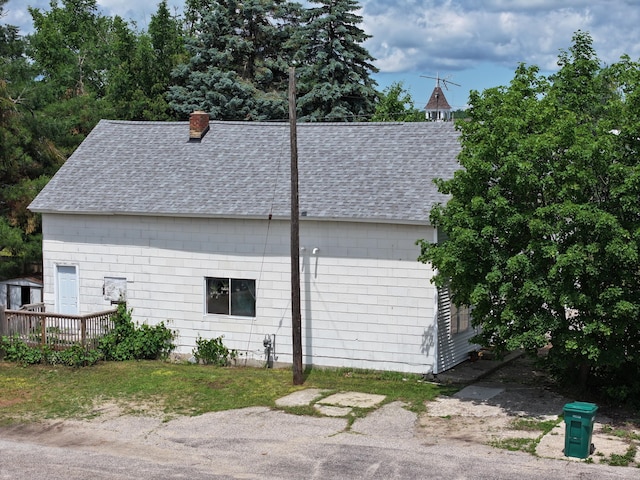 7931 Mill St, Vanderbilt, MI 49795 - view of side of home with roof with shingles, a wooden deck, and a chimney