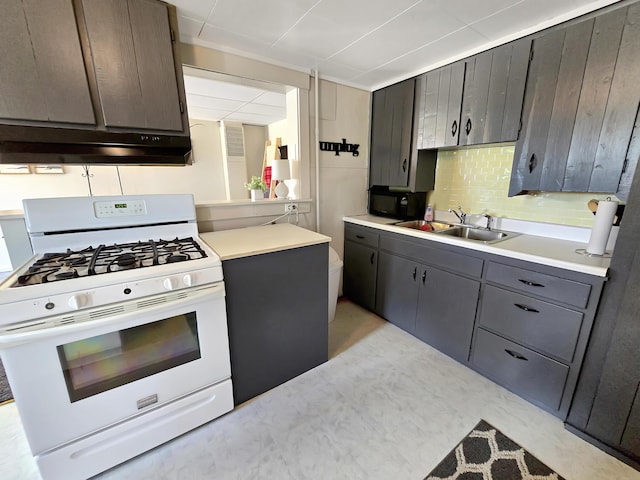 7931 Mill St, Vanderbilt, MI 49795 - kitchen with white gas range, under cabinet range hood, backsplash, light countertops, and gray cabinetry