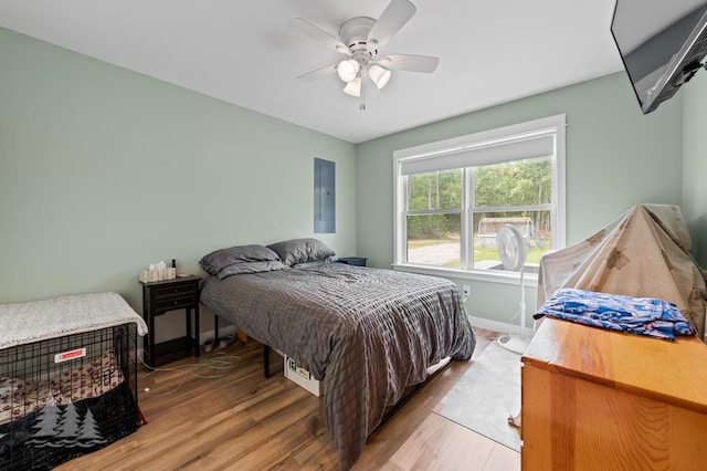 4620 Pinewood Dr, Lewiston, MI 49756 - bedroom featuring electric panel, light wood-style floors, and ceiling fan