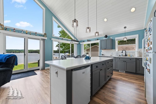 4620 Pinewood Dr, Lewiston, MI 49756 - kitchen featuring refrigerator, gray cabinets, light countertops, a kitchen island, and a water view