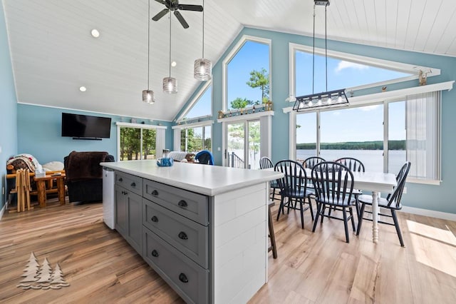 4620 Pinewood Dr, Lewiston, MI 49756 - kitchen with gray cabinetry, ceiling fan, light countertops, a kitchen island, and open floor plan