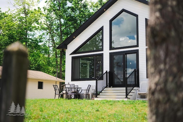 4620 Pinewood Dr, Lewiston, MI 49756 - rear view of property featuring entry steps and a lawn