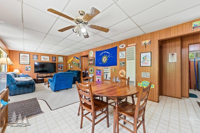 2911 Birch St, Lewiston, MI 49756 - dining space featuring wood walls, a paneled ceiling, light flooring, and a ceiling fan