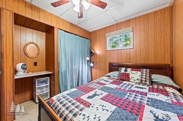 2911 Birch St, Lewiston, MI 49756 - bedroom with wooden walls, ceiling fan, and carpet flooring