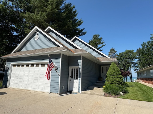 169 Pine Bluffs Rd, Roscommon, MI 48653 - view of front of property with driveway, a garage, and roof with shingles