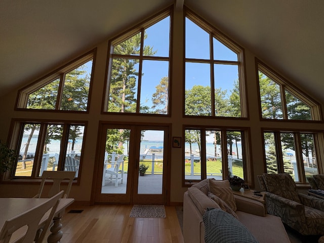 169 Pine Bluffs Rd, Roscommon, MI 48653 - living area featuring a water view, high vaulted ceiling, and plenty of natural light