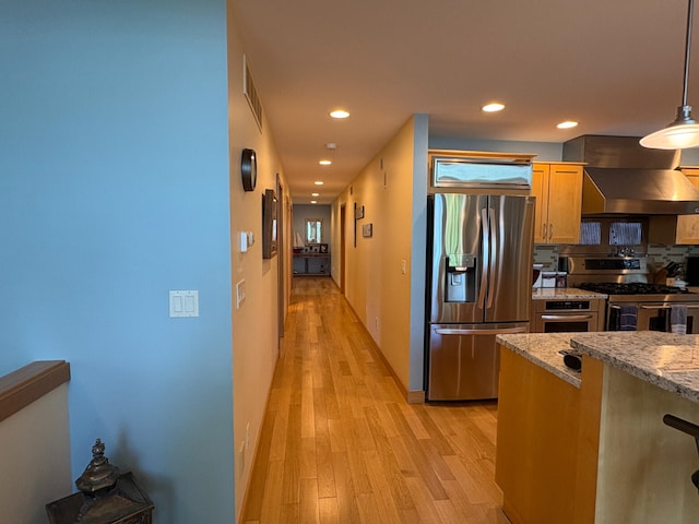 169 Pine Bluffs Rd, Roscommon, MI 48653 - kitchen with stainless steel appliances, wall chimney exhaust hood, light wood finished floors, recessed lighting, and pendant lighting