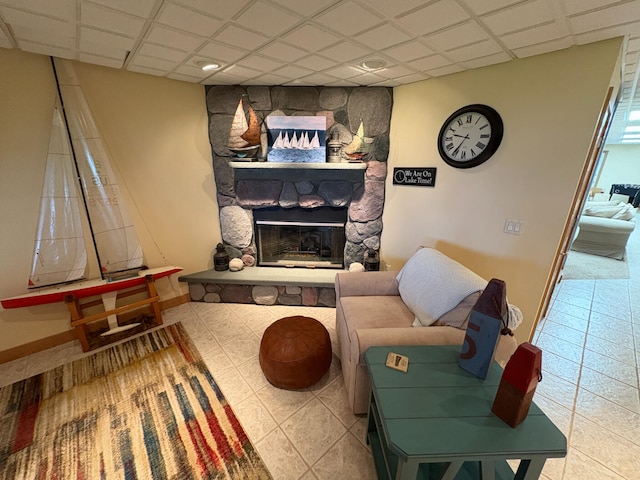 169 Pine Bluffs Rd, Roscommon, MI 48653 - tiled living room featuring a stone fireplace, a drop ceiling, and recessed lighting