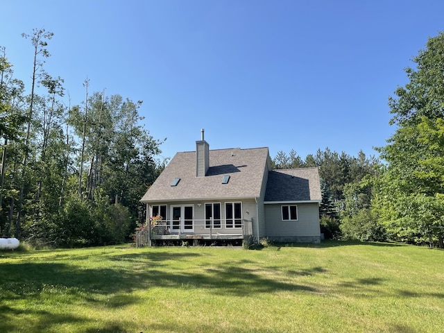 12395 Atkinson Rd, Lachine, MI 49753 - rear view of house featuring a yard, a chimney, a deck, and roof with shingles
