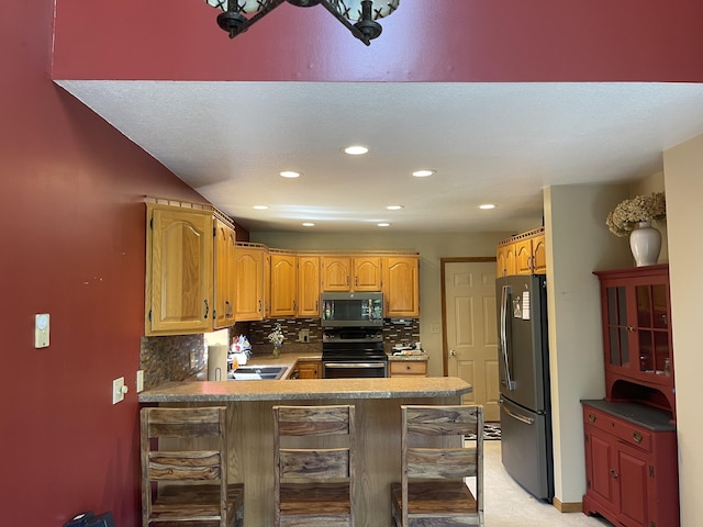 12395 Atkinson Rd, Lachine, MI 49753 - kitchen with stainless steel appliances, a peninsula, backsplash, recessed lighting, and a kitchen bar