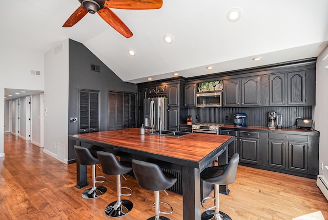 319 Old Trl, Houghton Lake, MI 48629 - kitchen with appliances with stainless steel finishes, high vaulted ceiling, butcher block counters, a ceiling fan, and light wood finished floors