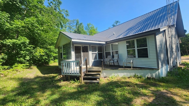 1025 Lake Side Trl, Barton City, MI 48705 - back of property featuring a deck, a sunroom, and a metal roof
