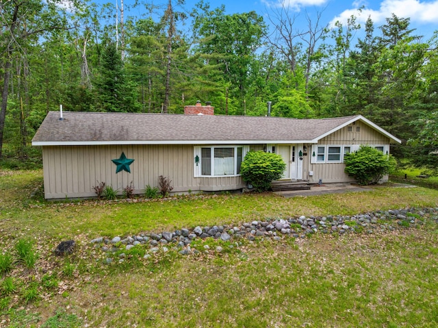 5699 N Red Oak Rd, Lewiston, MI 49756 - view of front of property featuring a shingled roof, a chimney, and a front yard