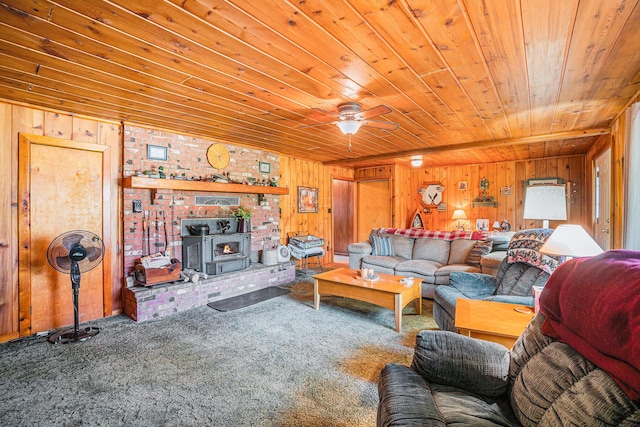 5699 N Red Oak Rd, Lewiston, MI 49756 - carpeted living room featuring wooden ceiling, a wood stove, wood walls, and ceiling fan