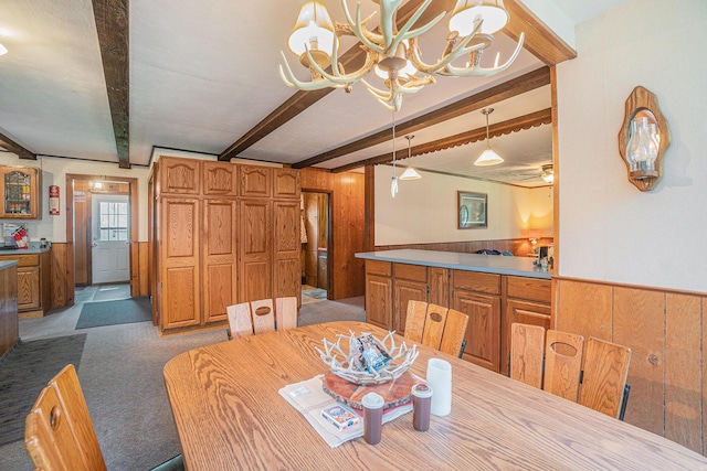 5699 N Red Oak Rd, Lewiston, MI 49756 - carpeted dining area with a chandelier, beamed ceiling, wood walls, and wainscoting