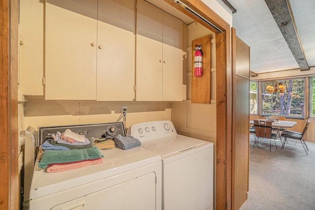 5699 N Red Oak Rd, Lewiston, MI 49756 - laundry room with washing machine and clothes dryer, a chandelier, and cabinet space