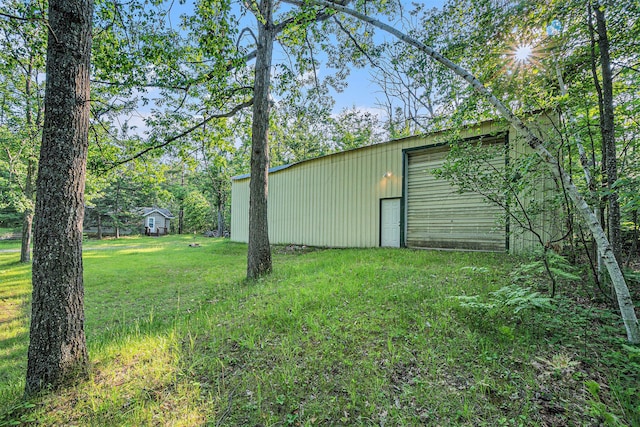 5699 N Red Oak Rd, Lewiston, MI 49756 - view of grassy yard featuring an outdoor structure, a garage, and an outbuilding