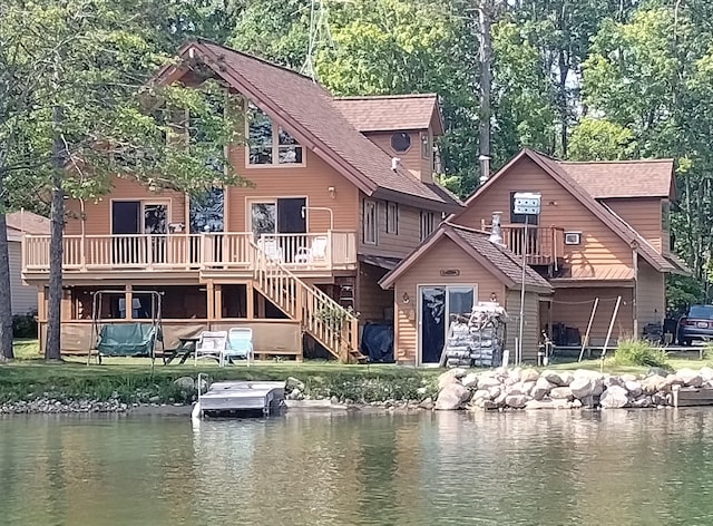 19241 Pine Tree Ct, Hillman, MI 49746 - rear view of house featuring a deck with water view, stairway, and roof with shingles