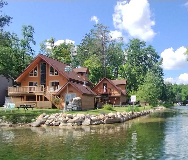 19241 Pine Tree Ct, Hillman, MI 49746 - rear view of house featuring a deck with water view, stairs, and a yard