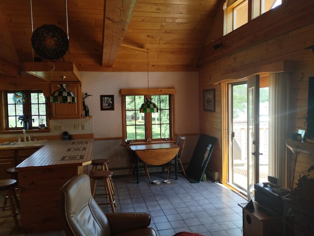 19241 Pine Tree Ct, Hillman, MI 49746 - dining room featuring wood ceiling, vaulted ceiling, wallpapered walls, and tile patterned floors