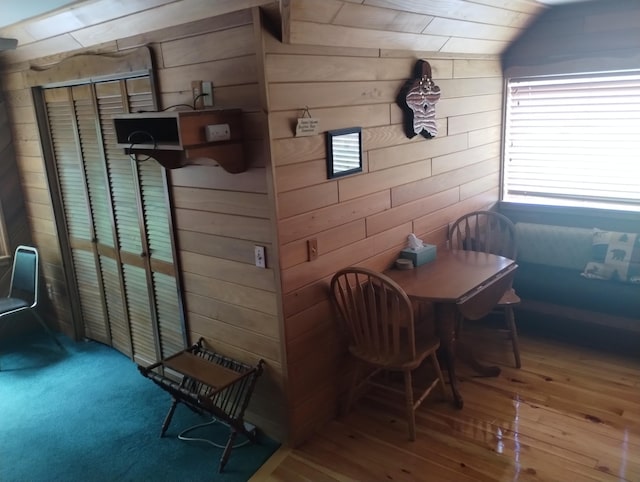 19241 Pine Tree Ct, Hillman, MI 49746 - dining area featuring wood walls, wood-type flooring, and lofted ceiling