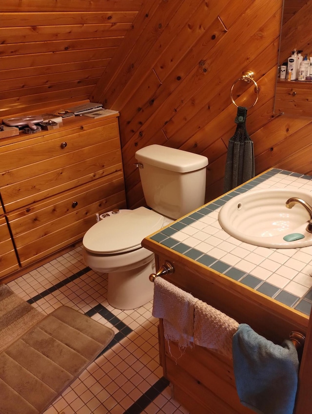 19241 Pine Tree Ct, Hillman, MI 49746 - half bathroom featuring wooden walls, vanity, and tile patterned flooring