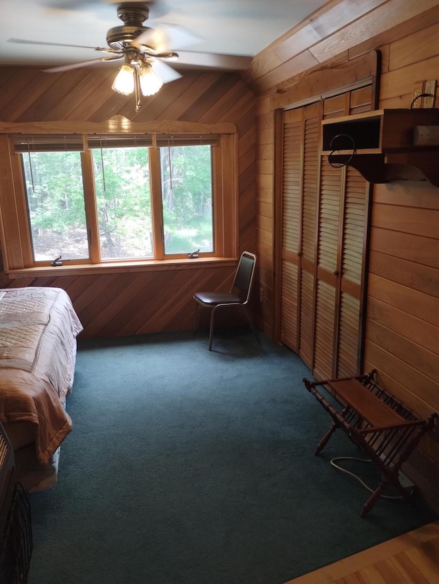 19241 Pine Tree Ct, Hillman, MI 49746 - carpeted bedroom featuring wood walls, a closet, and ceiling fan