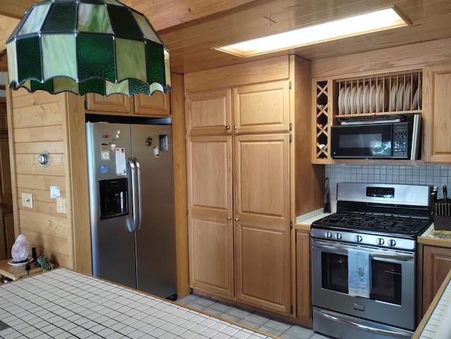 19241 Pine Tree Ct, Hillman, MI 49746 - kitchen featuring stainless steel appliances, light tile patterned floors, tile countertops, and tasteful backsplash