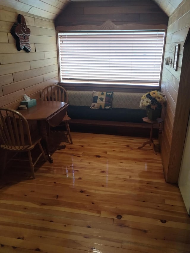 19241 Pine Tree Ct, Hillman, MI 49746 - dining room featuring light wood-style flooring, wood walls, and lofted ceiling