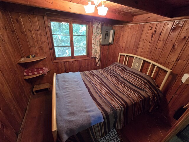 1987 N Galbraith Rd, Mio, MI 48647 - bedroom featuring wood walls, electric panel, a chandelier, and a wooden ceiling with exposed beams