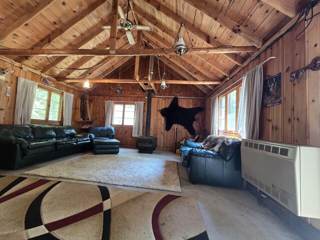 1987 N Galbraith Rd, Mio, MI 48647 - living room with a wood stove, healthy amount of natural light, wooden walls, a wooden ceiling with exposed beams, and heating unit