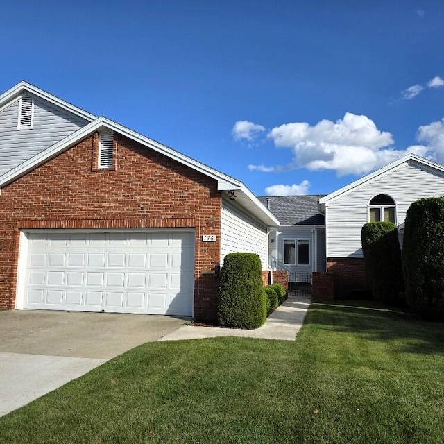 176 Long Rapids Rd, Alpena, MI 49707 - view of front of property with brick siding, concrete driveway, and a front yard