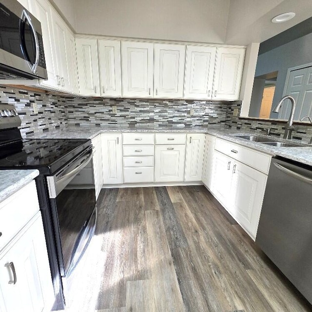 176 Long Rapids Rd, Alpena, MI 49707 - kitchen featuring stainless steel appliances, dark wood-type flooring, white cabinetry, and decorative backsplash