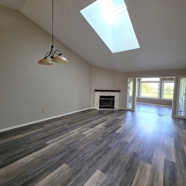 176 Long Rapids Rd, Alpena, MI 49707 - unfurnished living room with vaulted ceiling, dark wood-type flooring, a skylight, and a tile fireplace