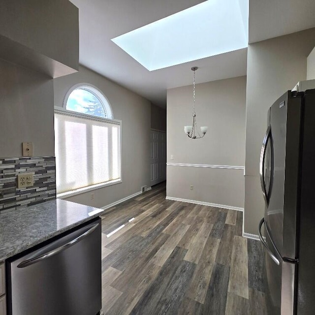 176 Long Rapids Rd, Alpena, MI 49707 - kitchen with stainless steel appliances, a skylight, a chandelier, dark wood-style flooring, and backsplash