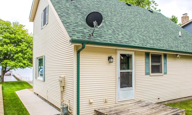 11920 W Shore Dr, Houghton Lake, MI 48629 - rear view of property featuring roof with shingles and a yard