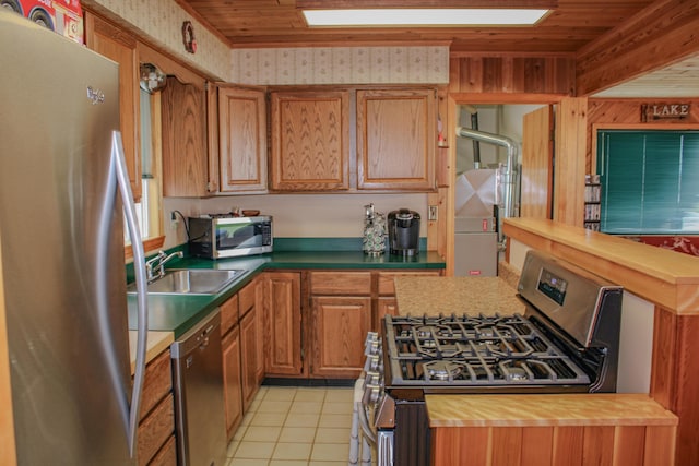 11920 W Shore Dr, Houghton Lake, MI 48629 - kitchen featuring appliances with stainless steel finishes, butcher block countertops, light tile patterned floors, wooden ceiling, and brown cabinetry