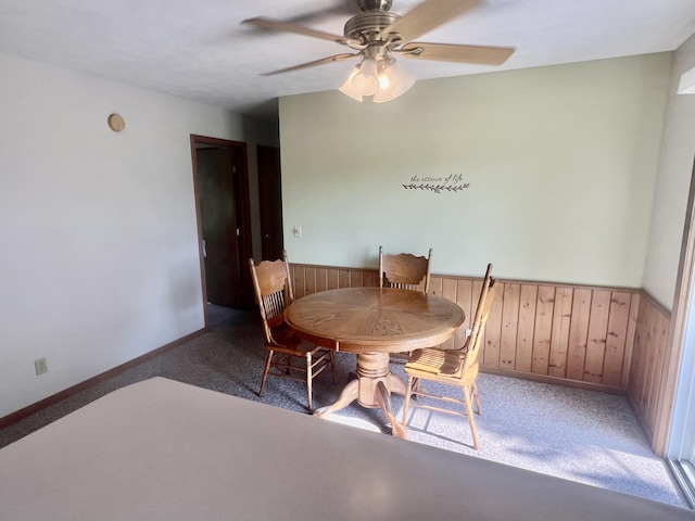 7125 S Military Rd, Grayling, MI 49738 - dining area featuring carpet, ceiling fan, wainscoting, and wood walls