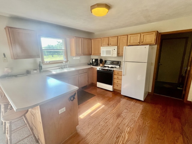 7125 S Military Rd, Grayling, MI 49738 - kitchen featuring white appliances, light brown cabinets, a peninsula, light countertops, and wood finished floors
