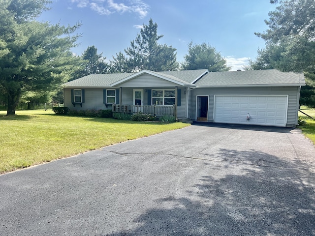 7125 S Military Rd, Grayling, MI 49738 - ranch-style home with a porch, a garage, asphalt driveway, a front lawn, and a shingled roof
