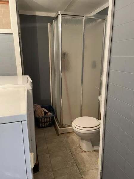 10279 N Sherman Rd, Frederic, MI 49733 - full bathroom featuring independent washer and dryer, vanity, and a stall shower