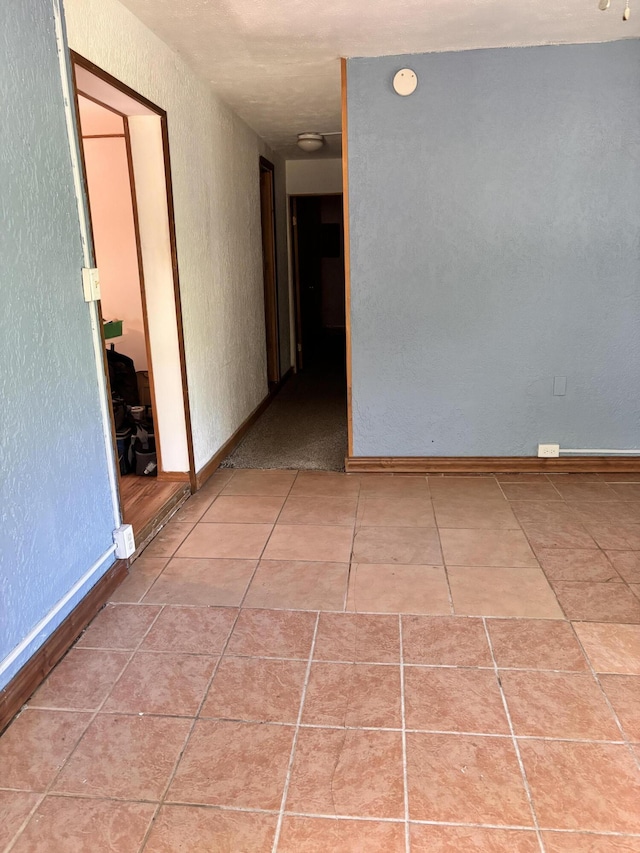 10279 N Sherman Rd, Frederic, MI 49733 - empty room featuring a textured wall and tile patterned flooring