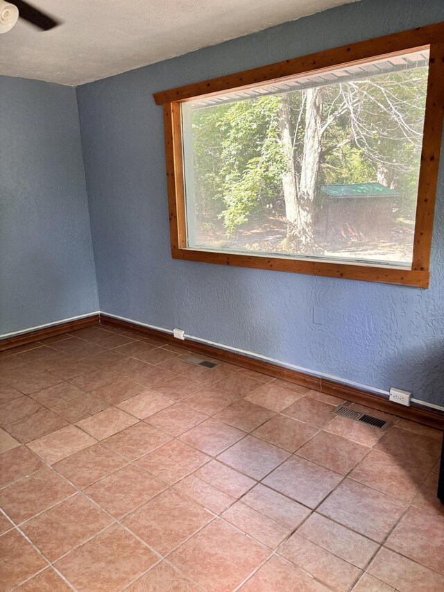 10279 N Sherman Rd, Frederic, MI 49733 - spare room featuring a textured wall and baseboards