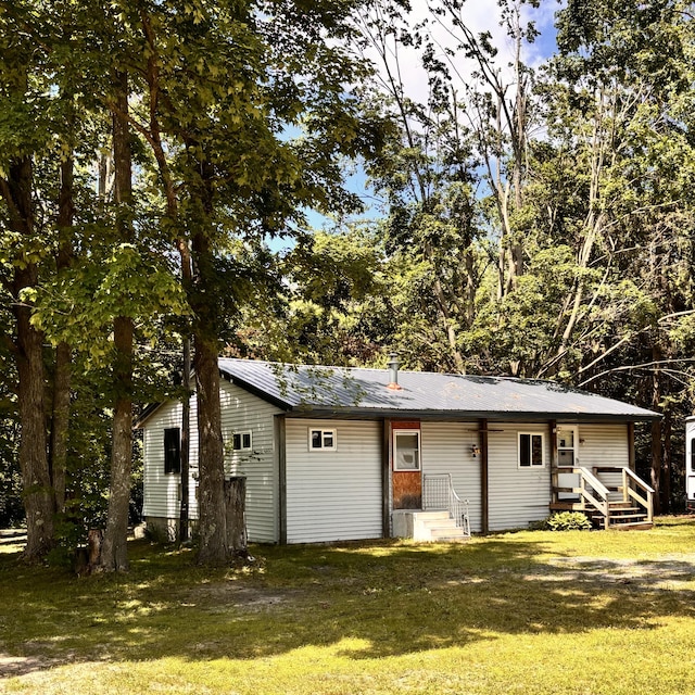 10279 N Sherman Rd, Frederic, MI 49733 - rear view of property with a yard and a metal roof