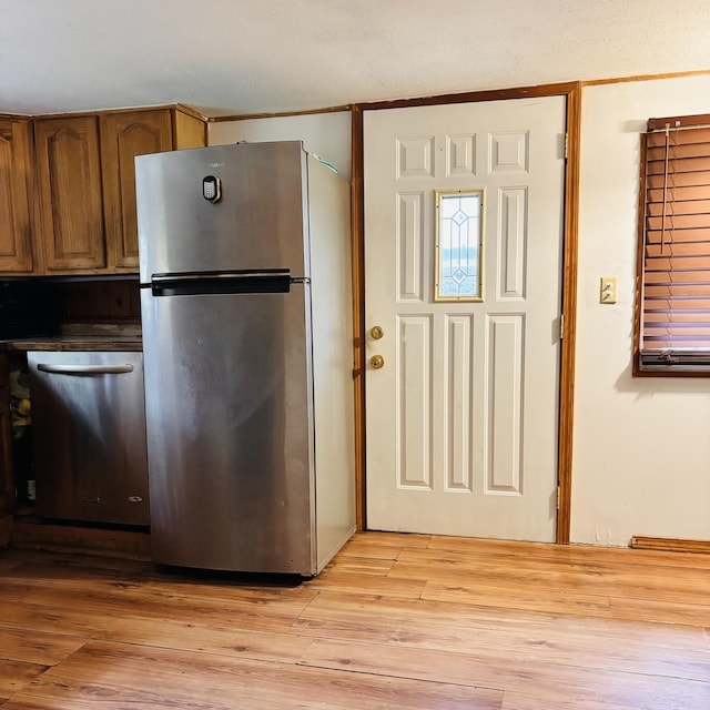 10279 N Sherman Rd, Frederic, MI 49733 - kitchen with appliances with stainless steel finishes, light wood-type flooring, and brown cabinetry